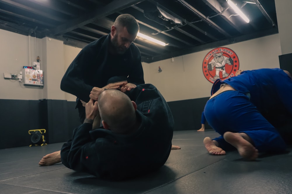 a man standing over another man in a gym