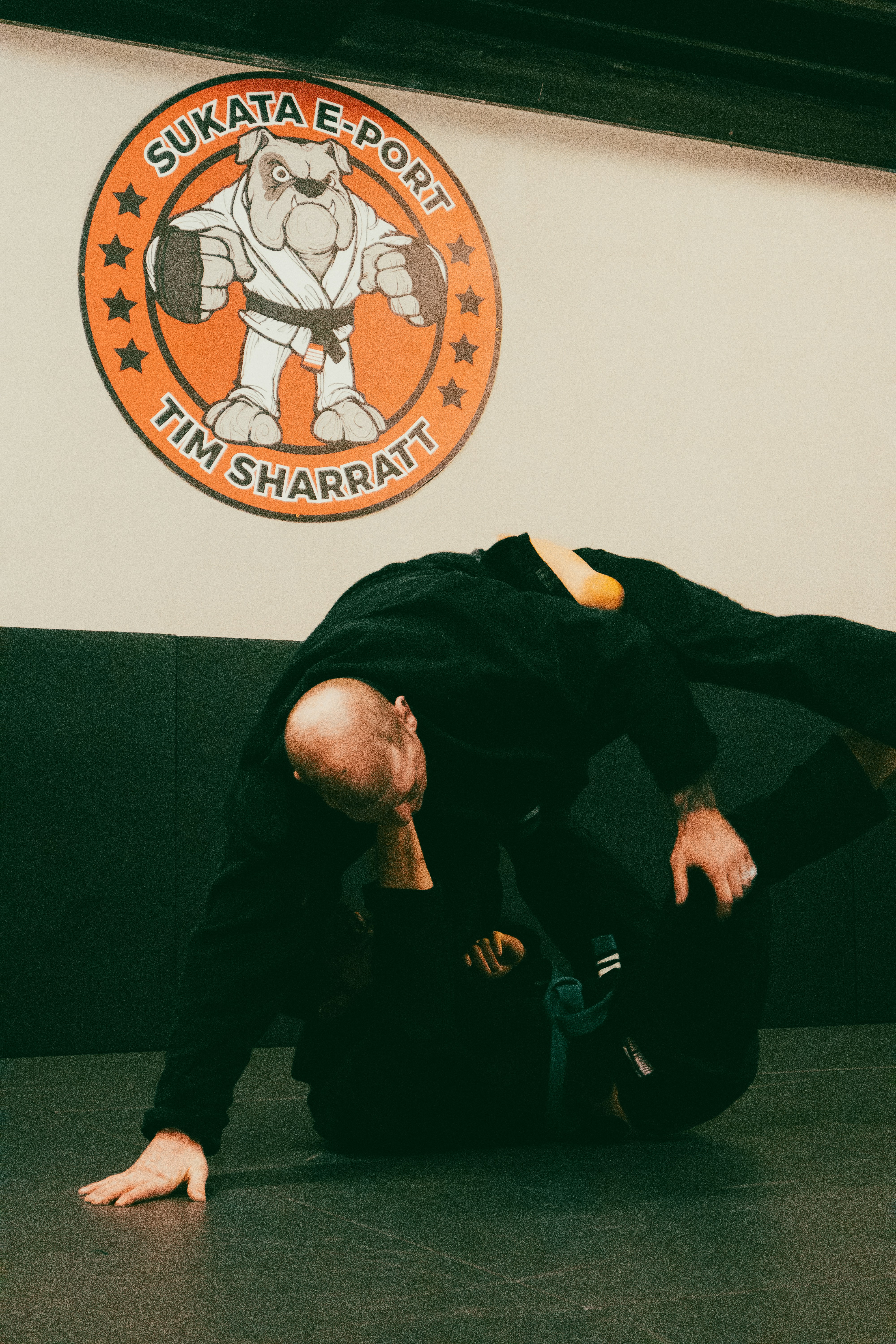 a man in black shirt doing a trick on a black mat