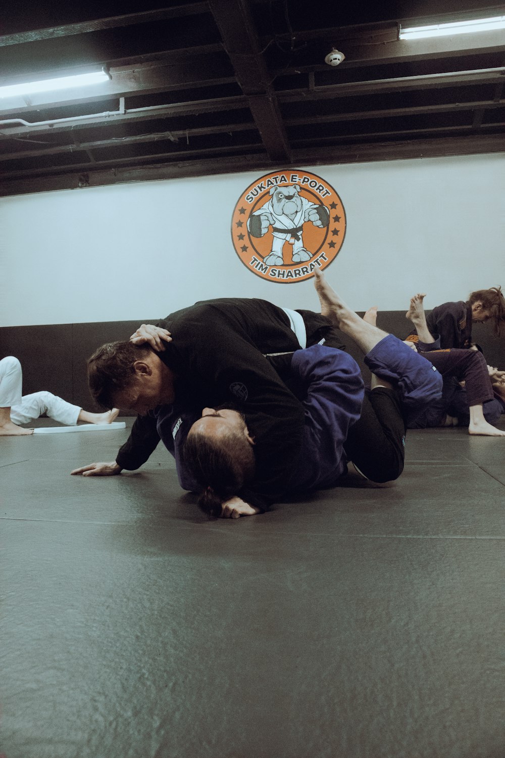 two people on a mat in a gym