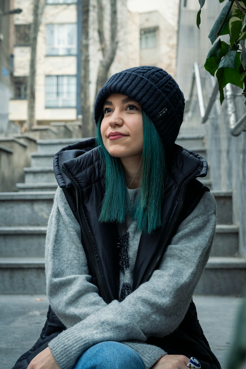 a woman with green hair sitting on steps