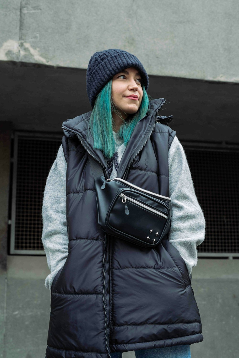 a woman with green hair wearing a black vest