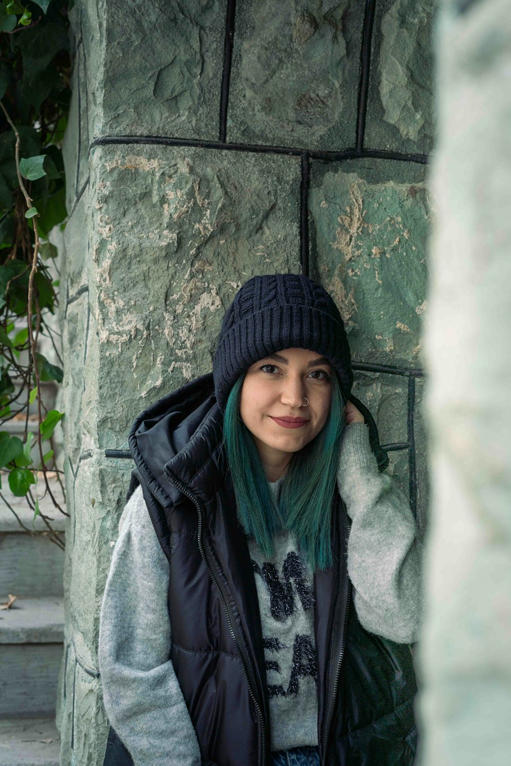 a woman with green hair wearing a black hat