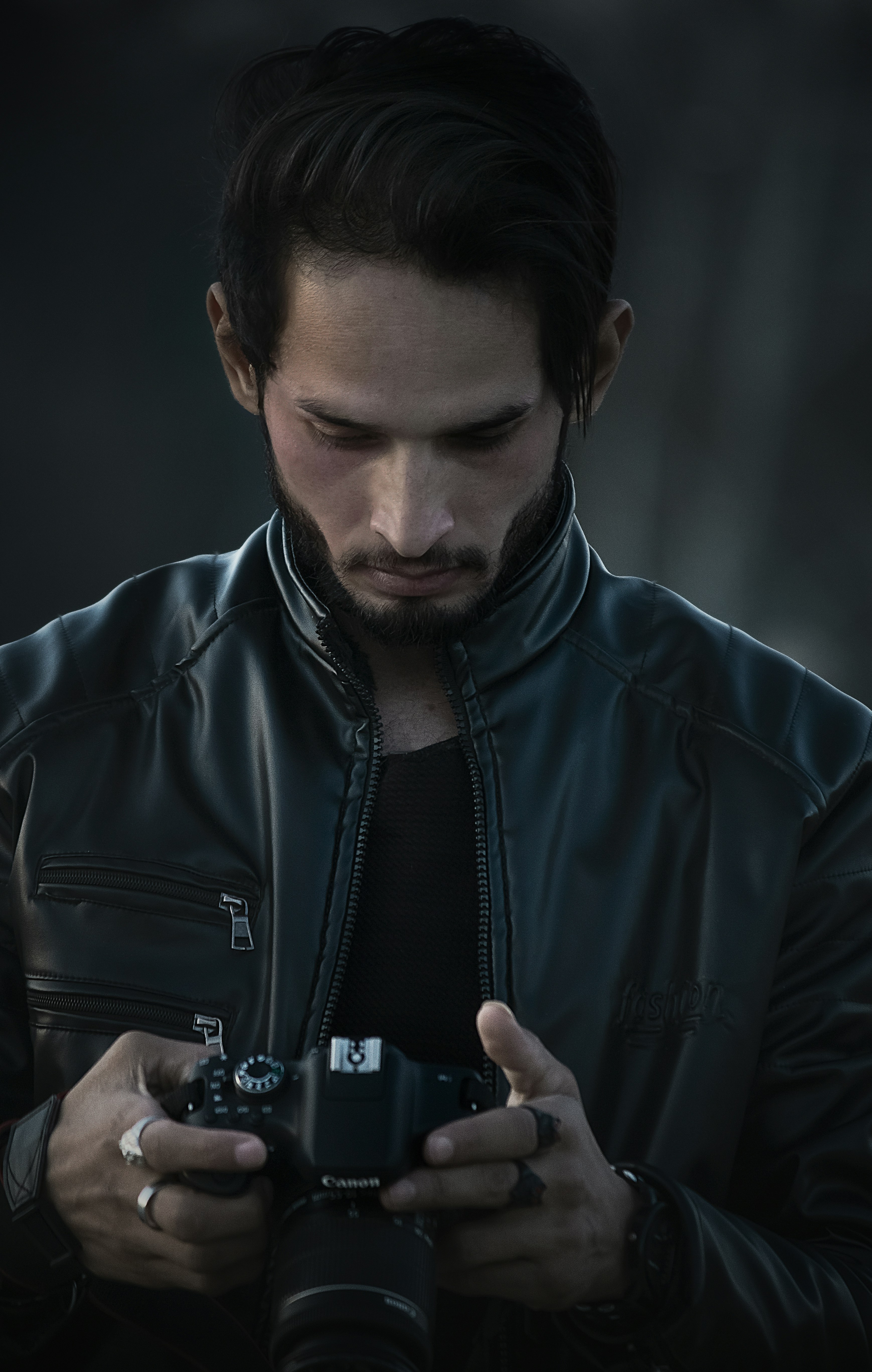 a man in a leather jacket holding a camera