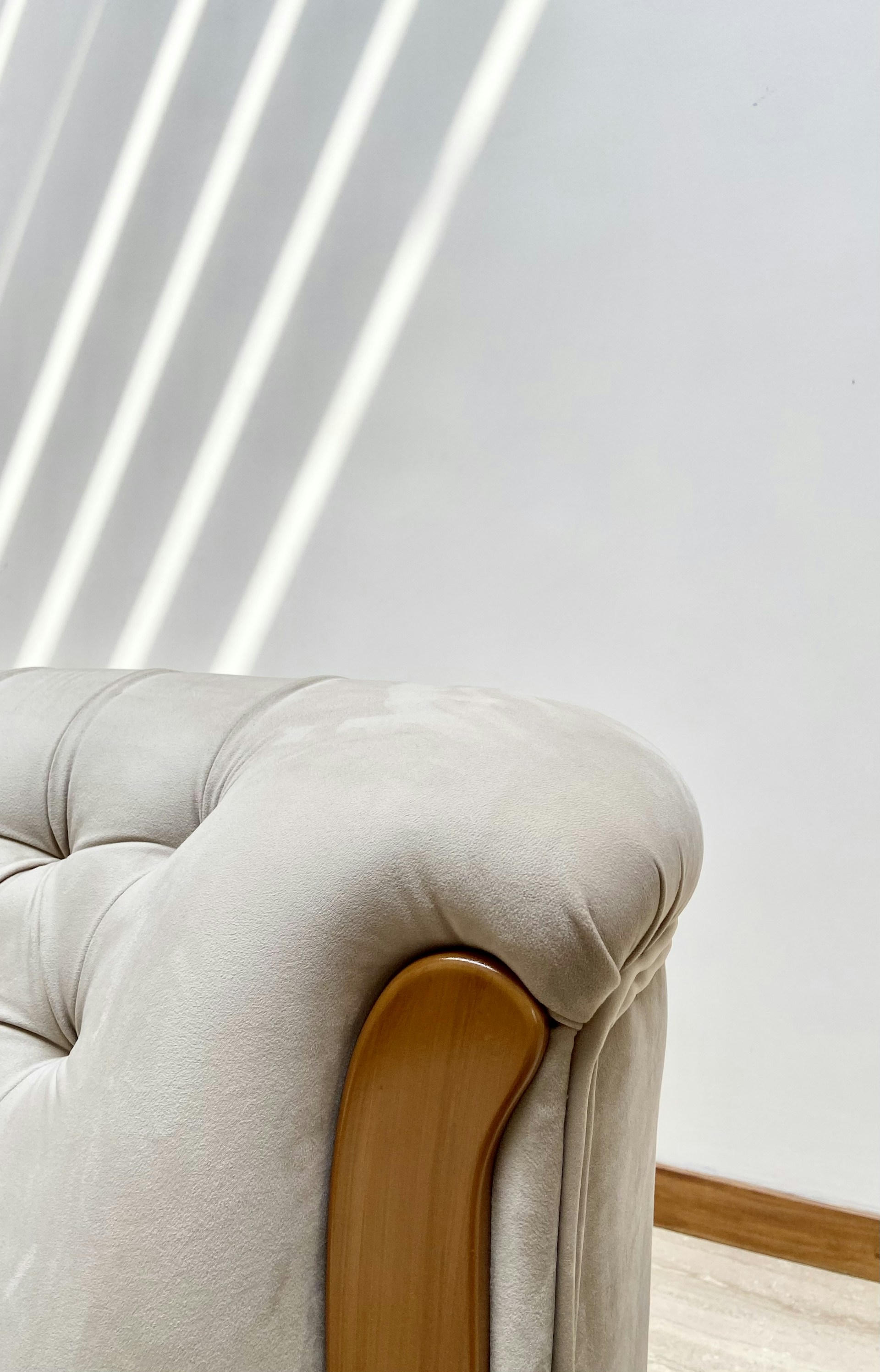 a white couch with a wooden arm rest