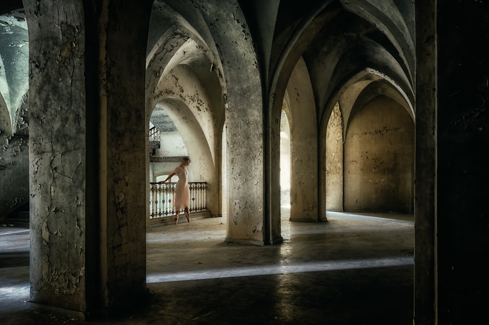 a dark room with arches and a staircase