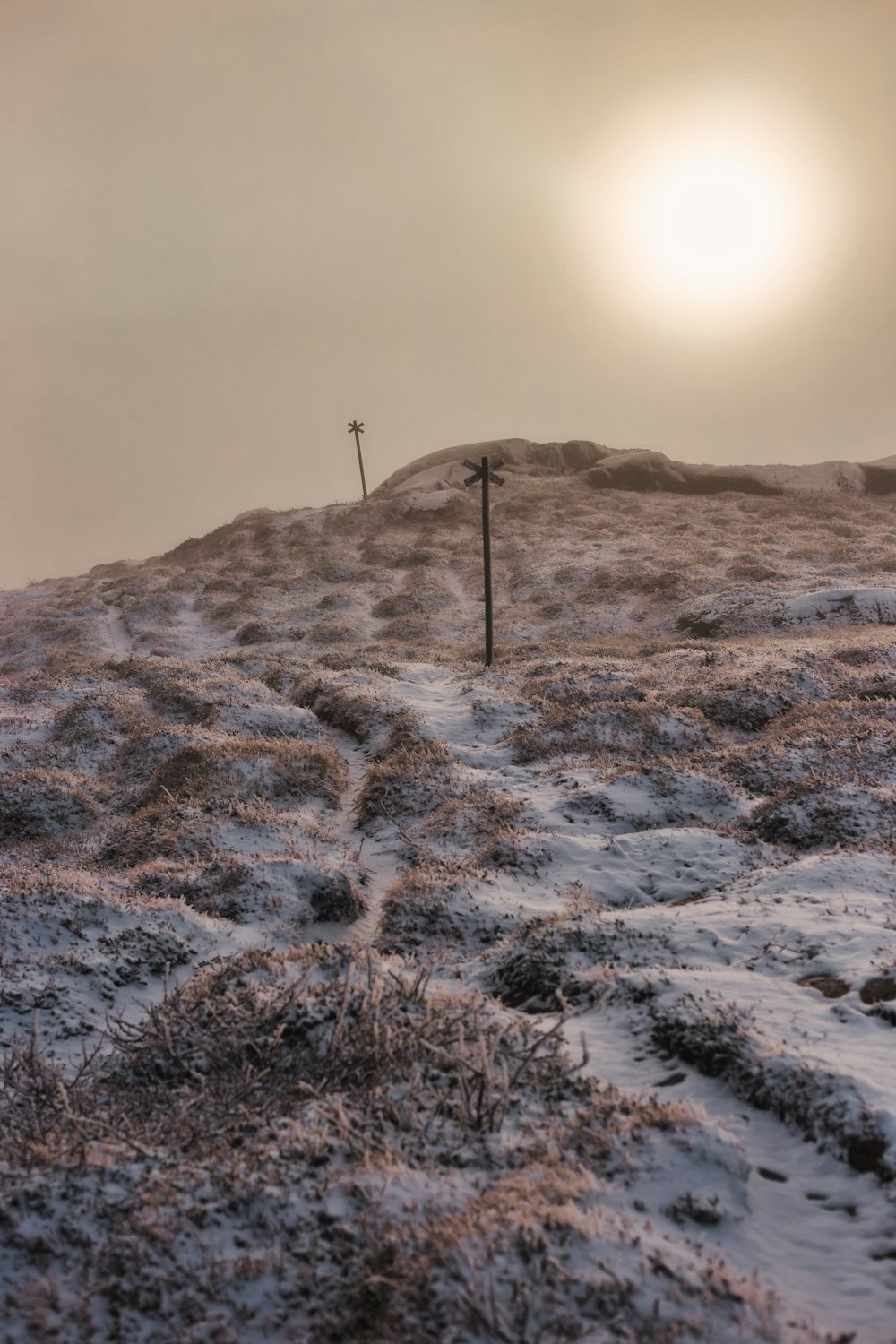 a cross on top of a hill covered in snow