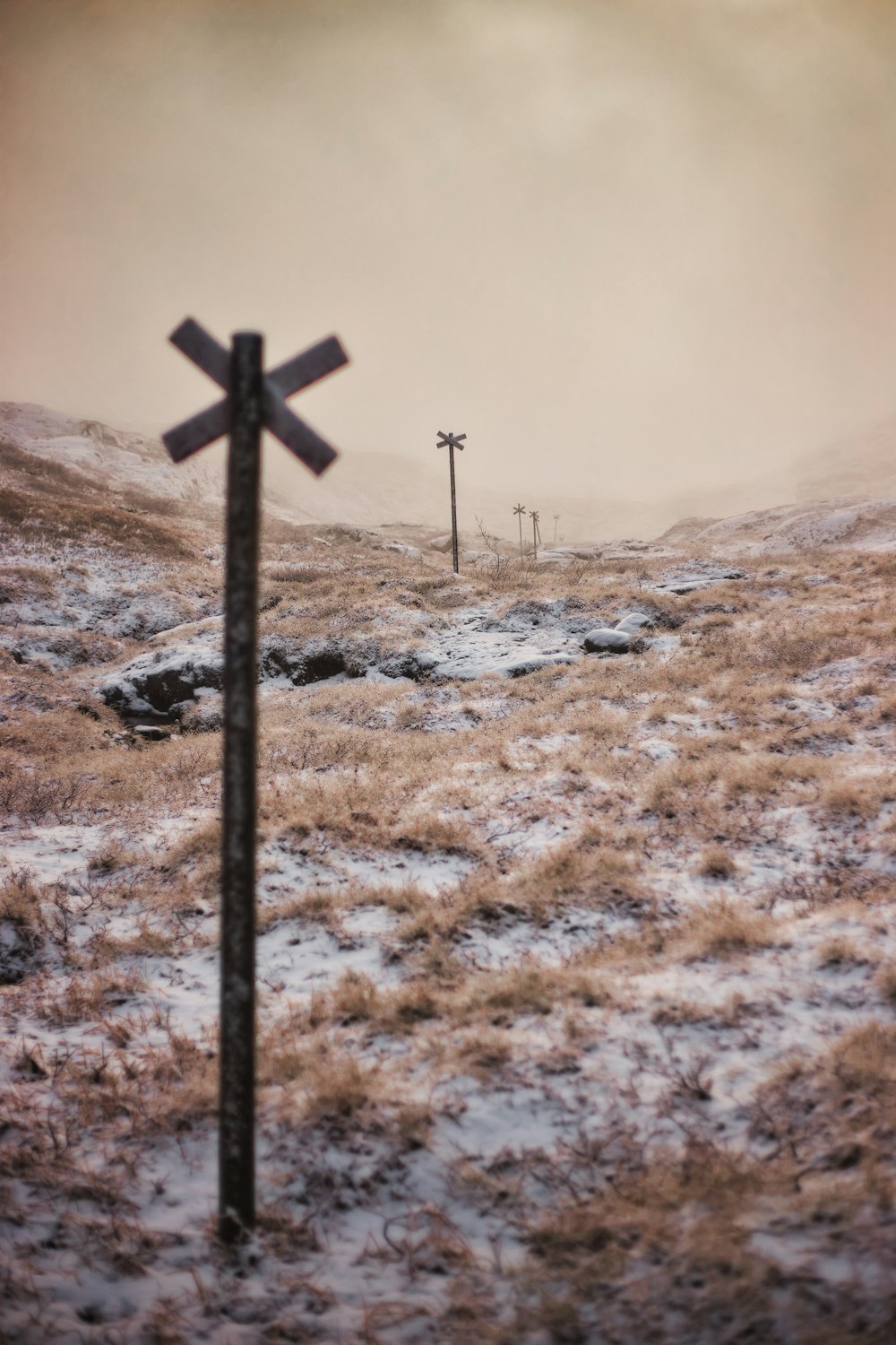 uma cruz no meio de um campo nevado