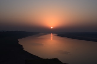 the sun is setting over a body of water