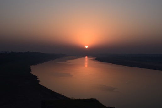 the sun is setting over a body of water