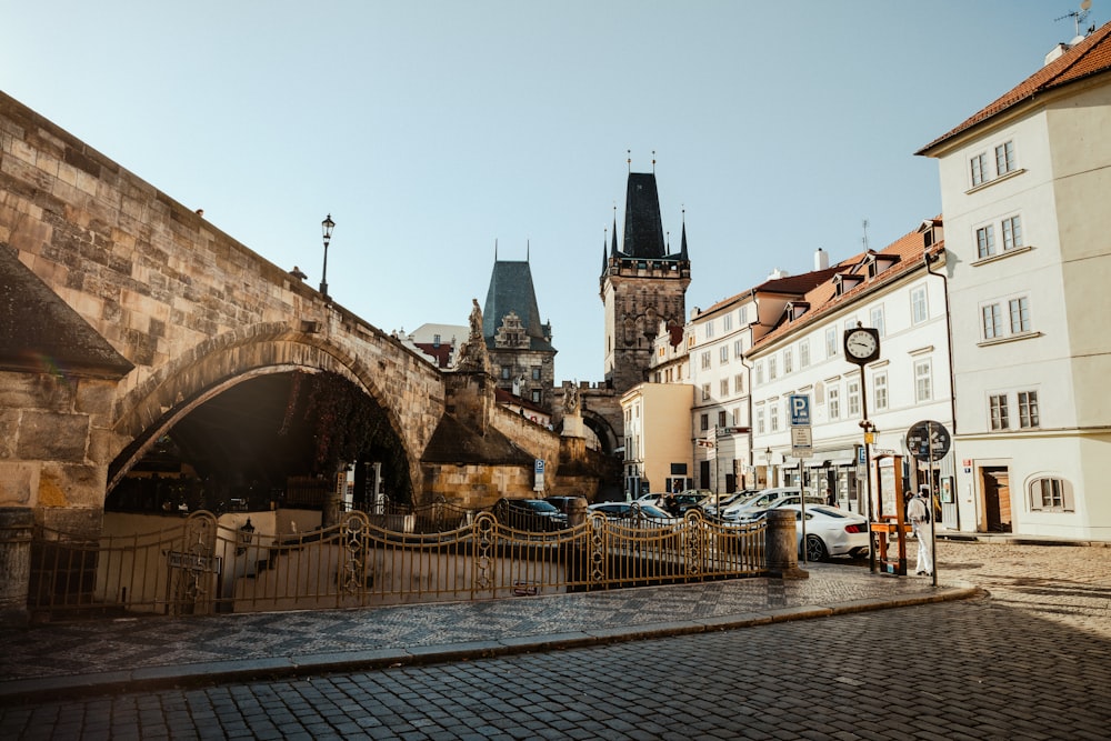 a city street with a bridge and a clock tower in the background