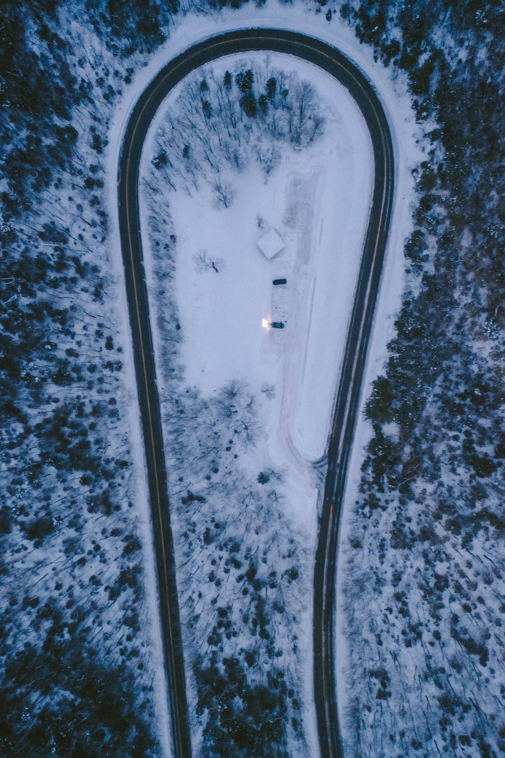 an aerial view of a winding road in the snow