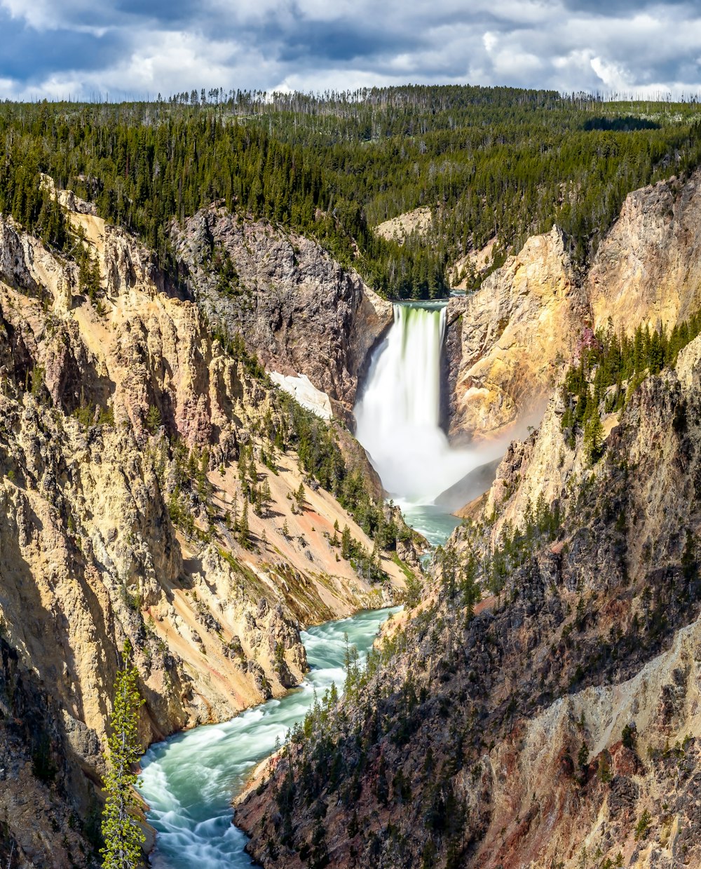 a view of a waterfall in the middle of a canyon