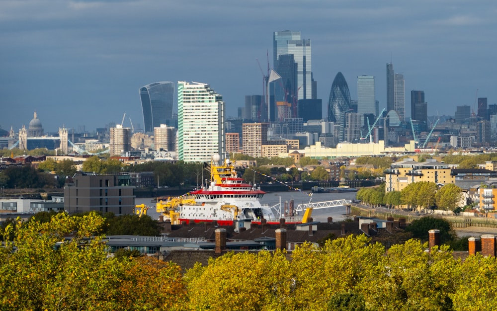 a city skyline with a large boat in the foreground