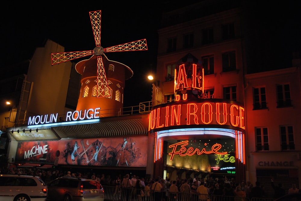 a group of people standing outside of a building at night