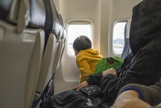 a small child sitting on a seat in an airplane