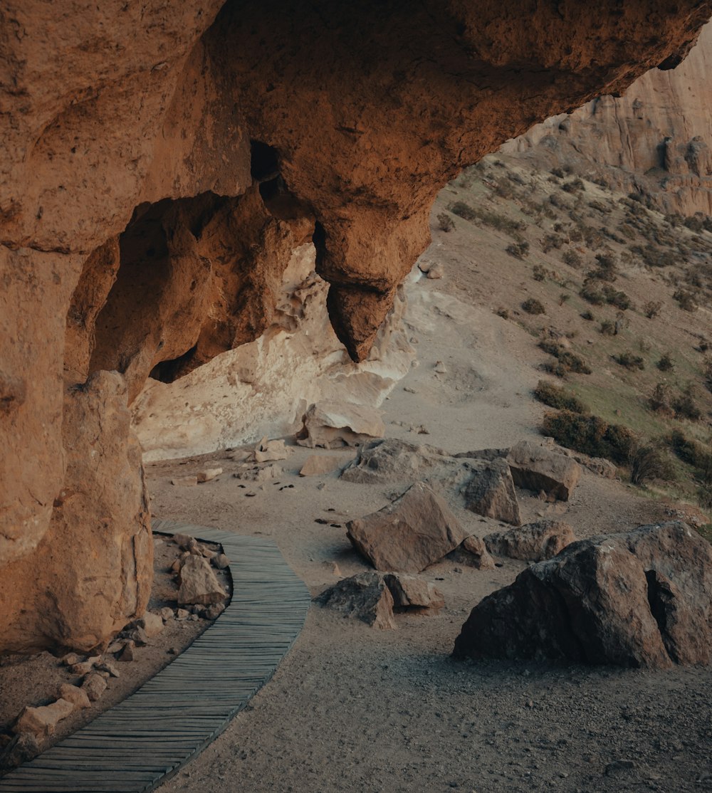 a wooden walkway leading to a cave in the desert