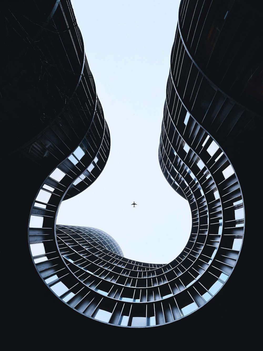 a plane flying through a very tall building