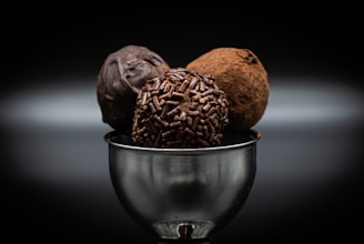Smooth milk chocolate truffles dusted with cocoa powder in a small bowl