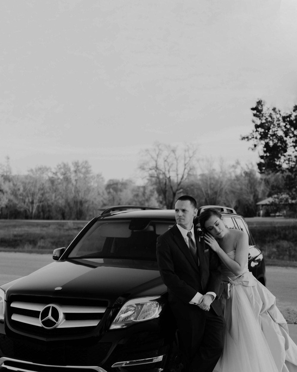a man and a woman standing next to a car