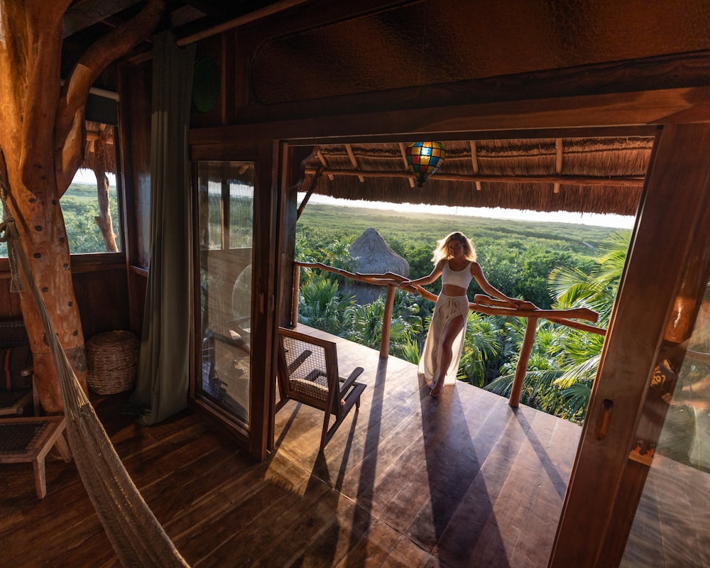 a woman in a white dress standing on a balcony