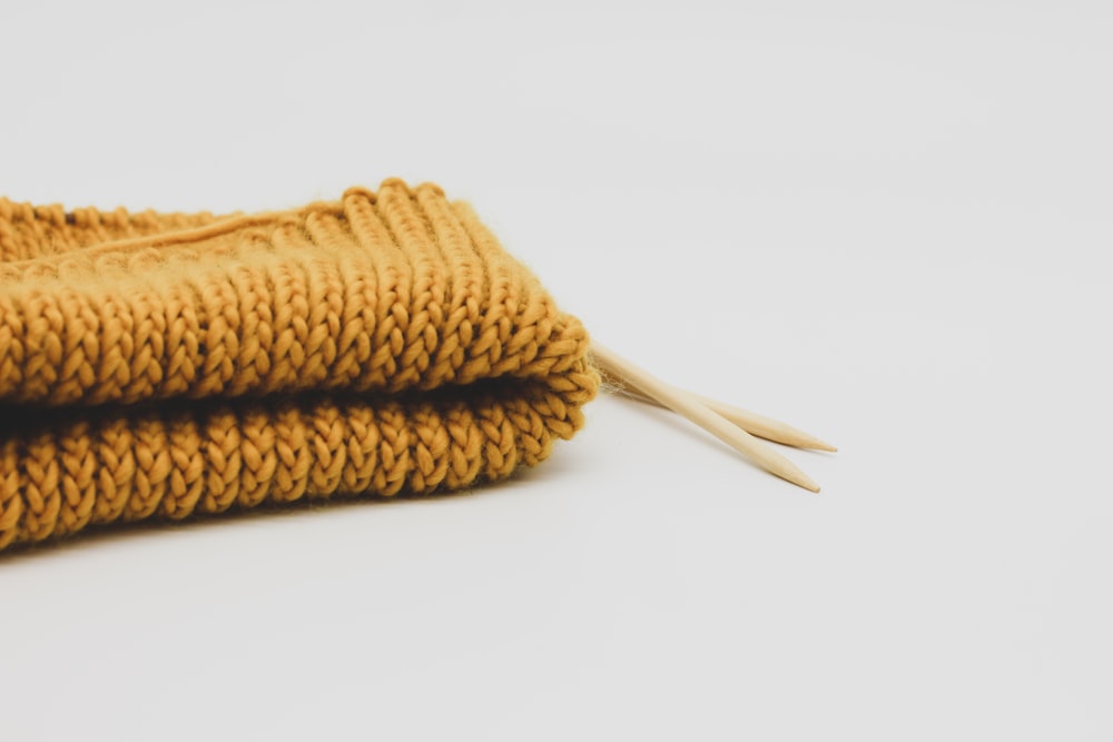 a pair of yellow knitted gloves sitting on top of each other