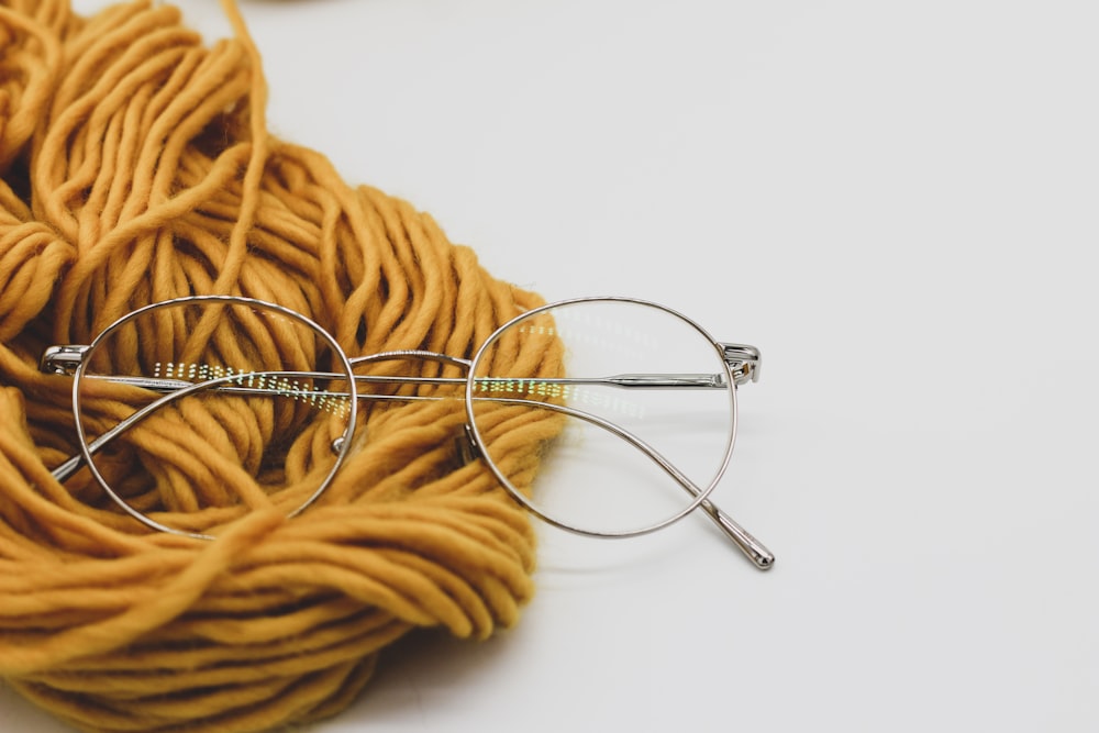 a ball of yarn and glasses on a white surface