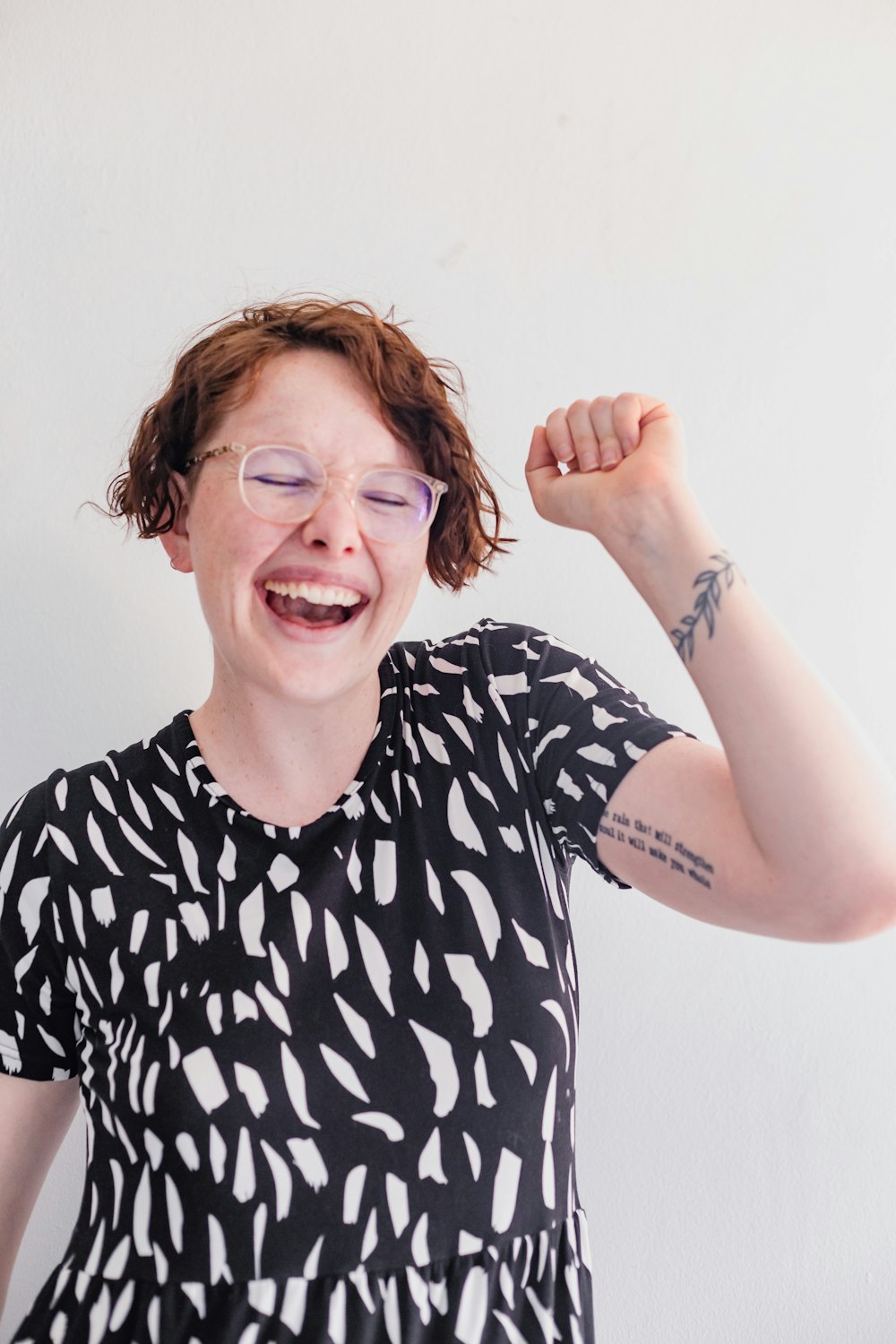 a woman wearing glasses and a black and white top