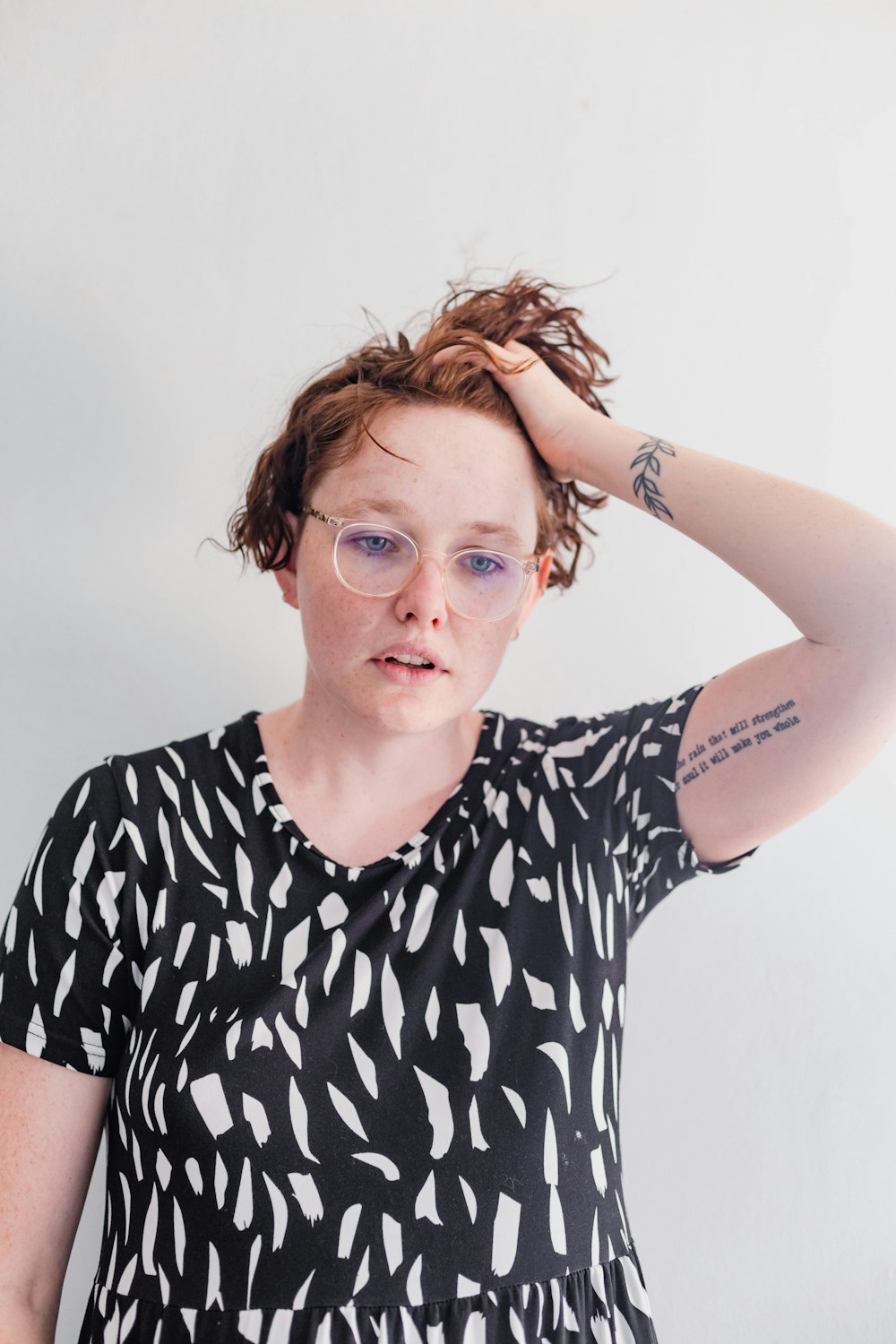 a woman with glasses and a black and white shirt