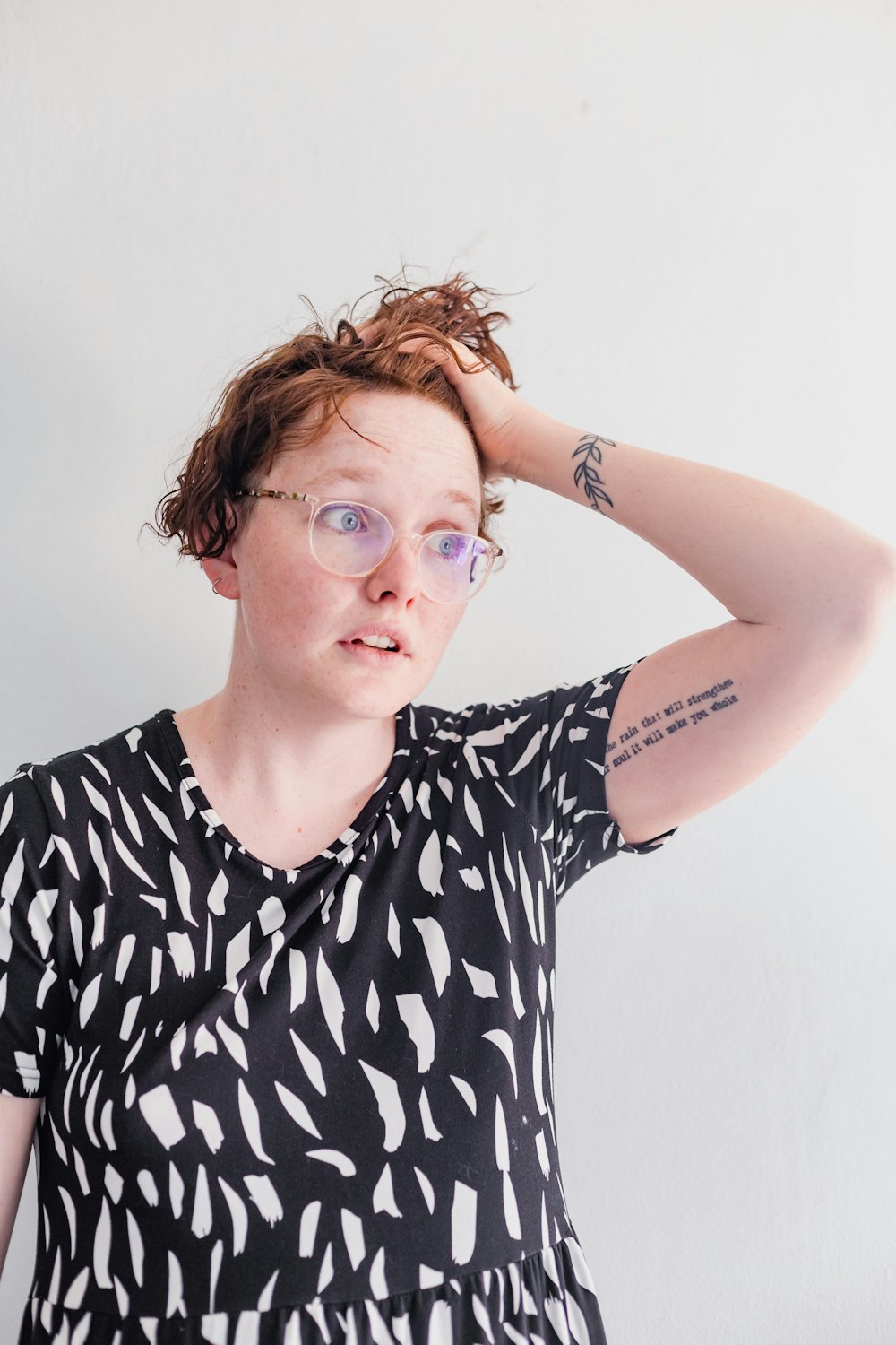 a woman wearing glasses and a black and white top