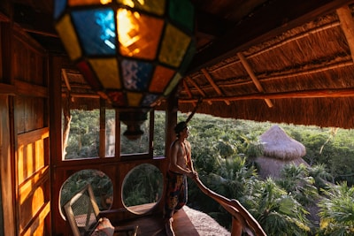 a woman standing on a porch next to a window