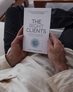 a person laying in bed holding a book