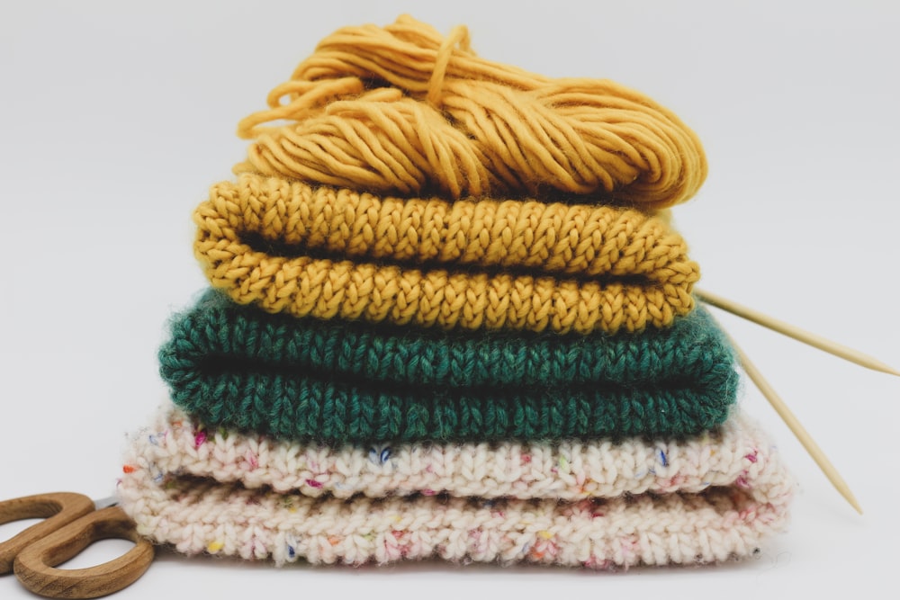 a stack of knitted items with a pair of scissors