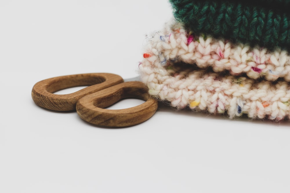 Un par de anillos de madera sentados junto a una pila de mantas tejidas