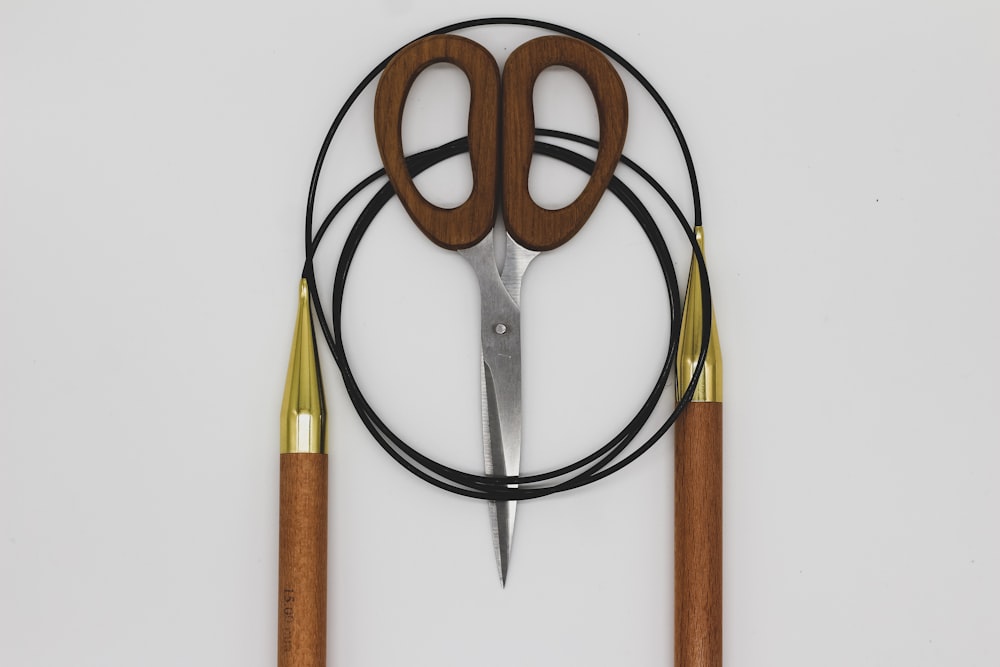 a pair of scissors sitting on top of a wooden handle