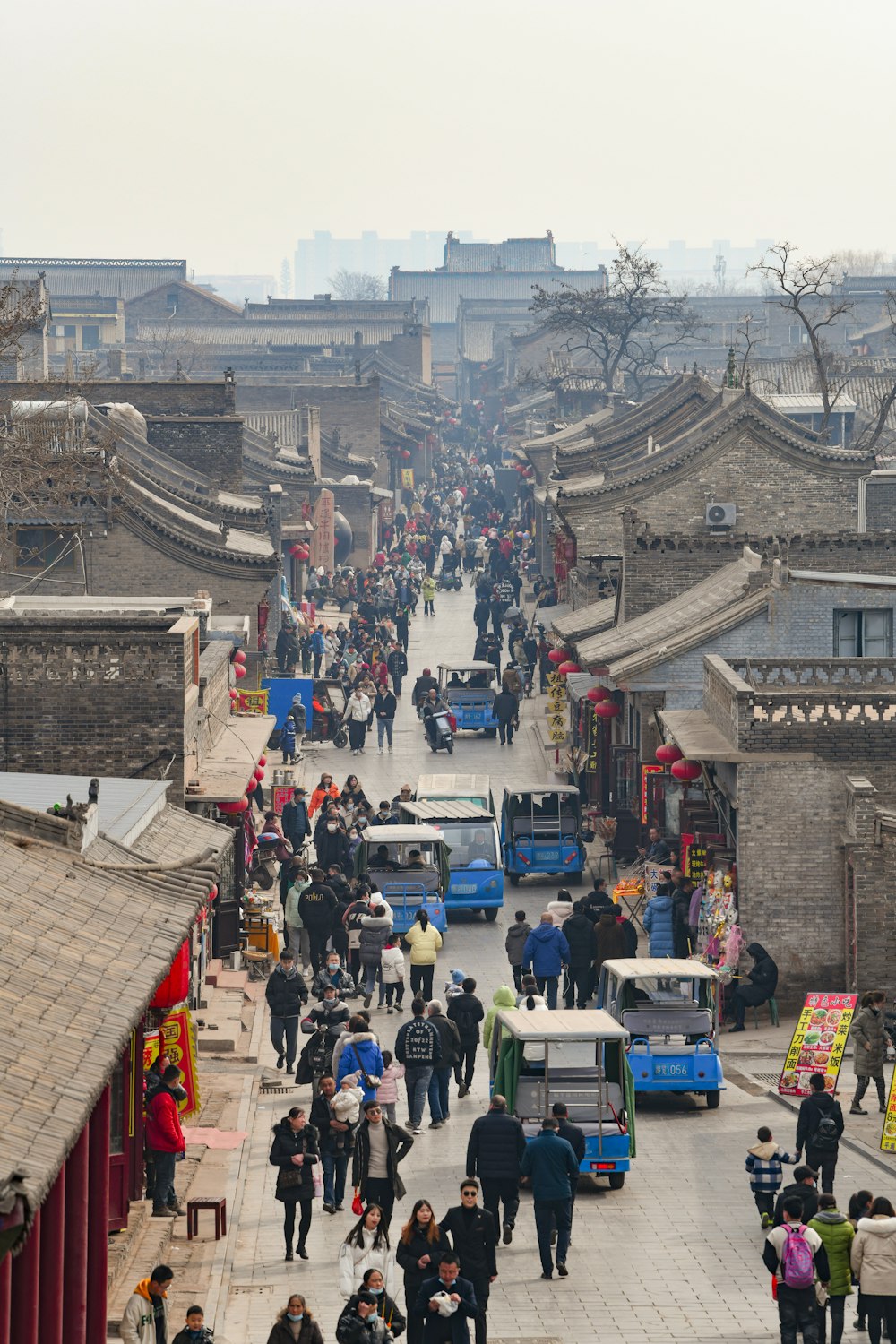 a group of people walking down a street next to buildings