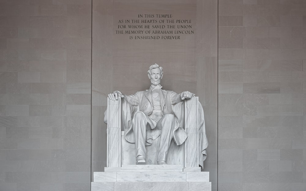 a statue of abraham lincoln sits in the lincoln memorial