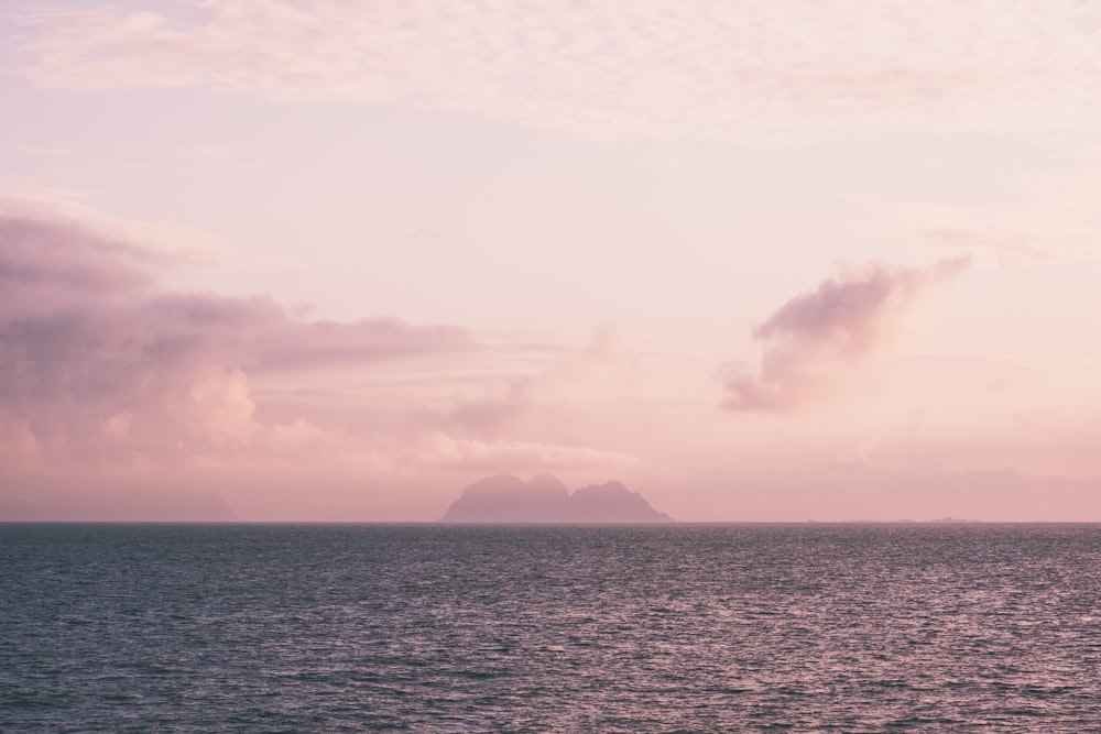 a large body of water with a small island in the distance