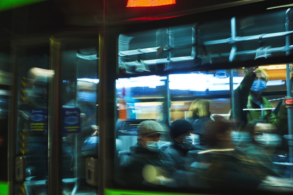 a group of people sitting on a bus at night