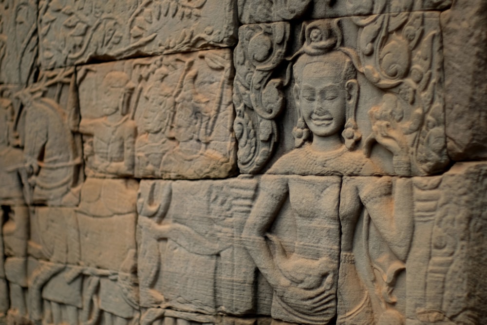 a close up of a stone wall with carvings on it