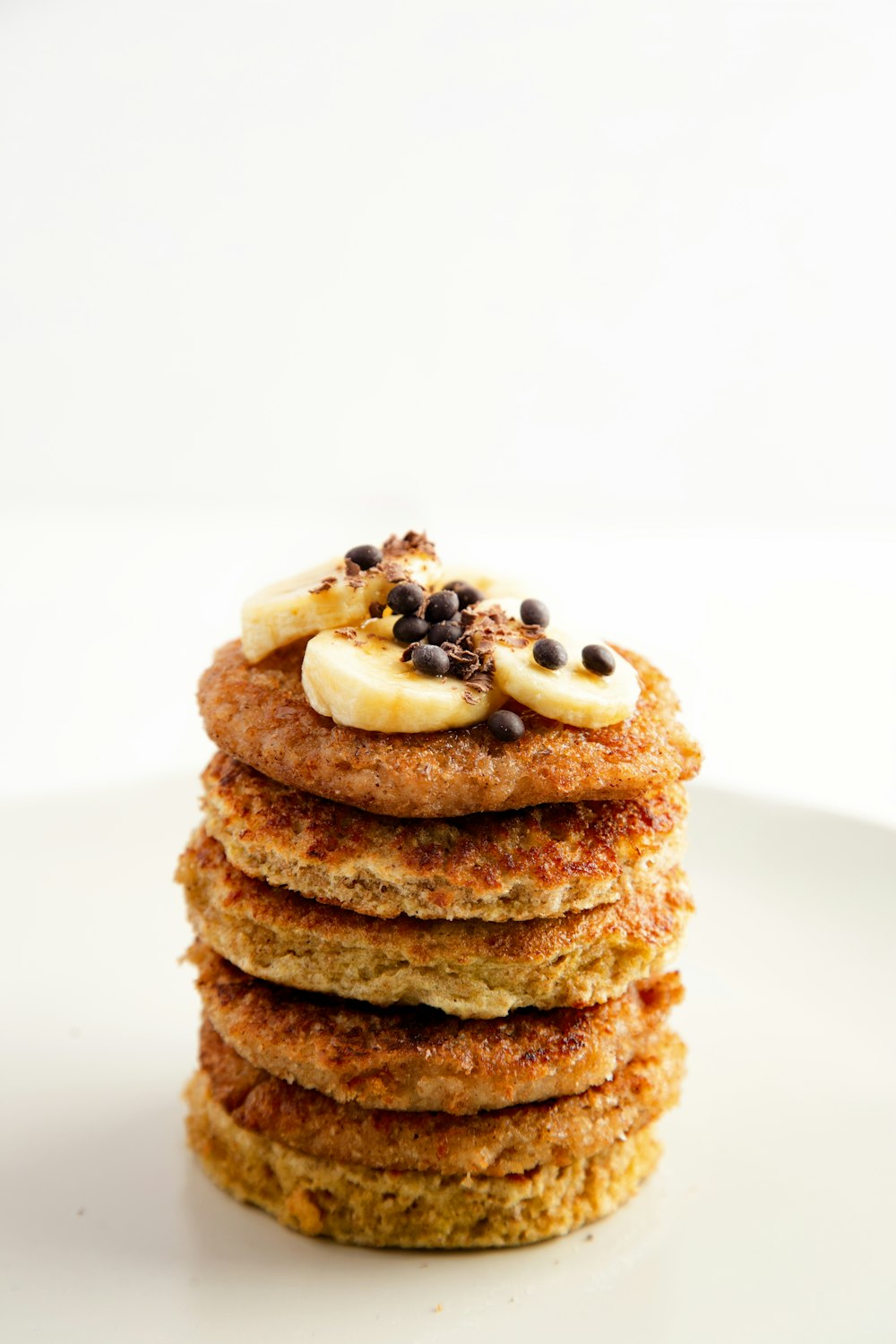 a stack of pancakes topped with bananas and chocolate chips