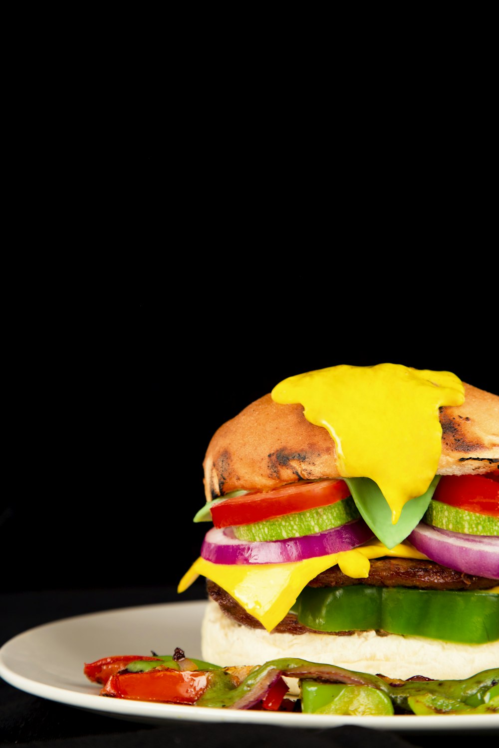 a large sandwich on a white plate on a black background