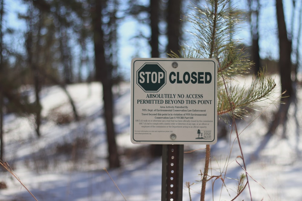 a sign is posted on a pole in the snow