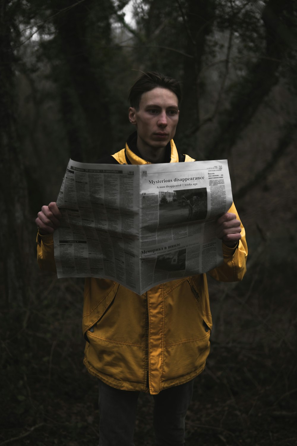 a man in a yellow jacket holding a newspaper