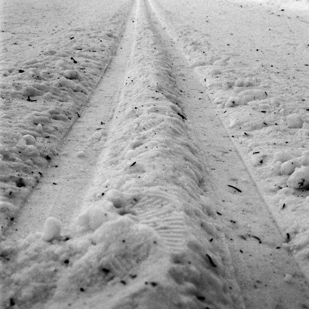 a tire track in the snow on the side of a road