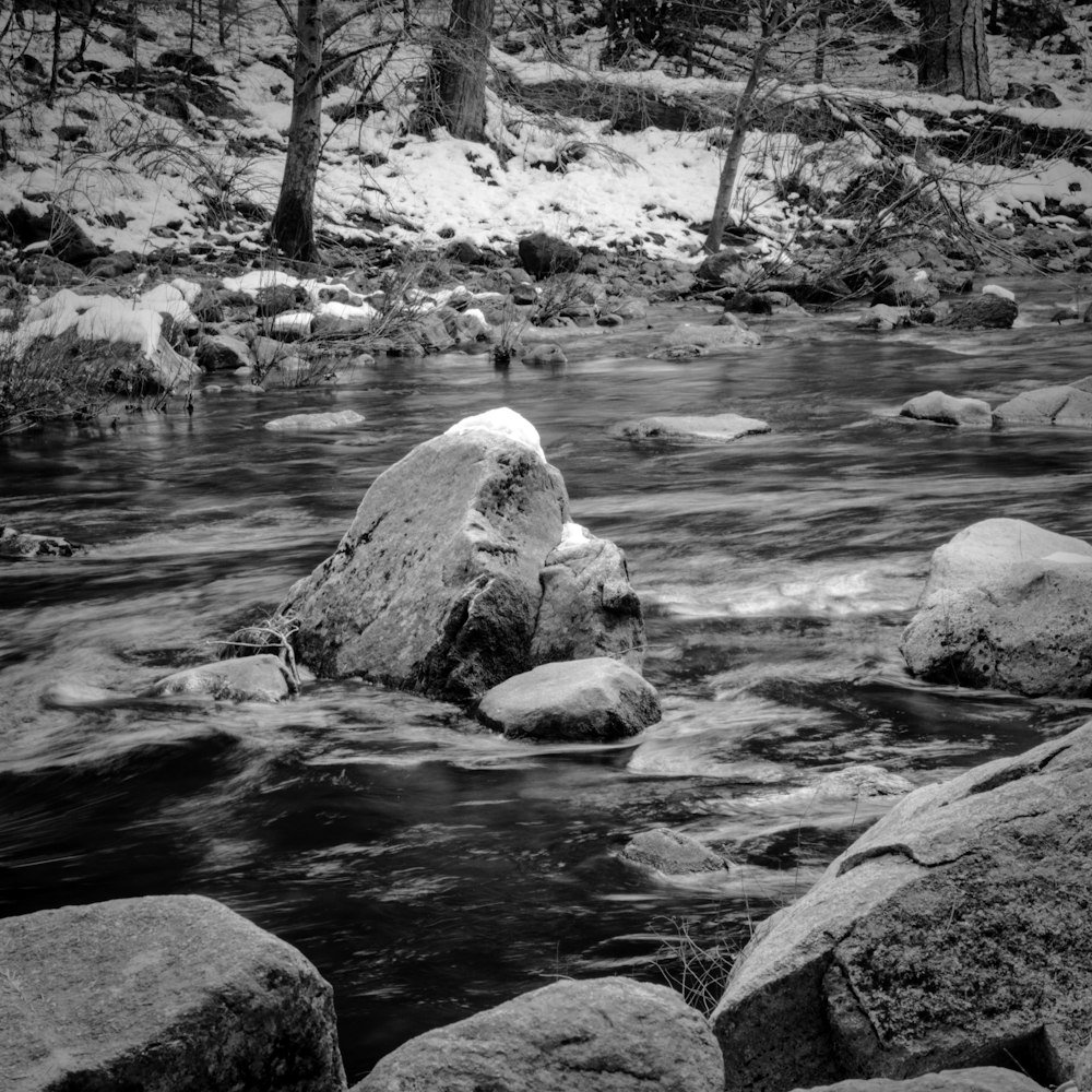 a black and white photo of rocks in a stream