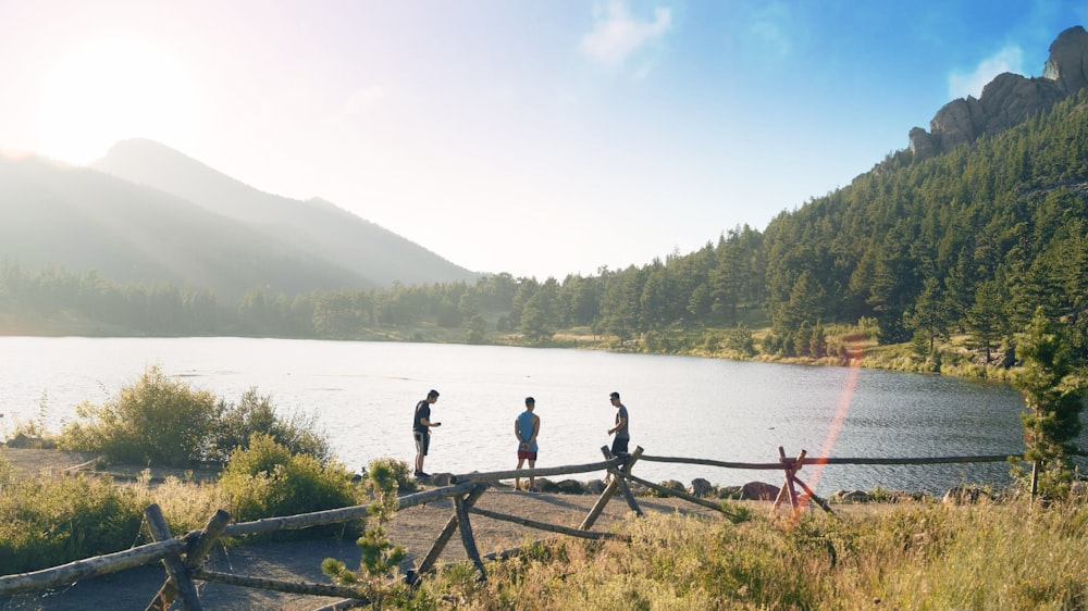 a group of people standing on a bridge over a lake