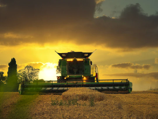 a large green truck driving down a dirt road