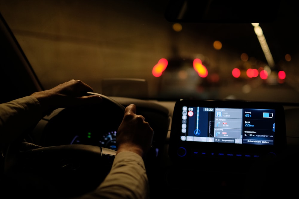 uma pessoa está dirigindo um carro à noite