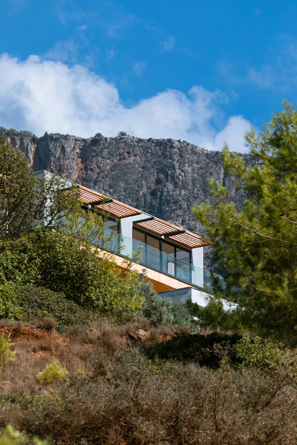 une maison au sommet d’une colline entourée d’arbres