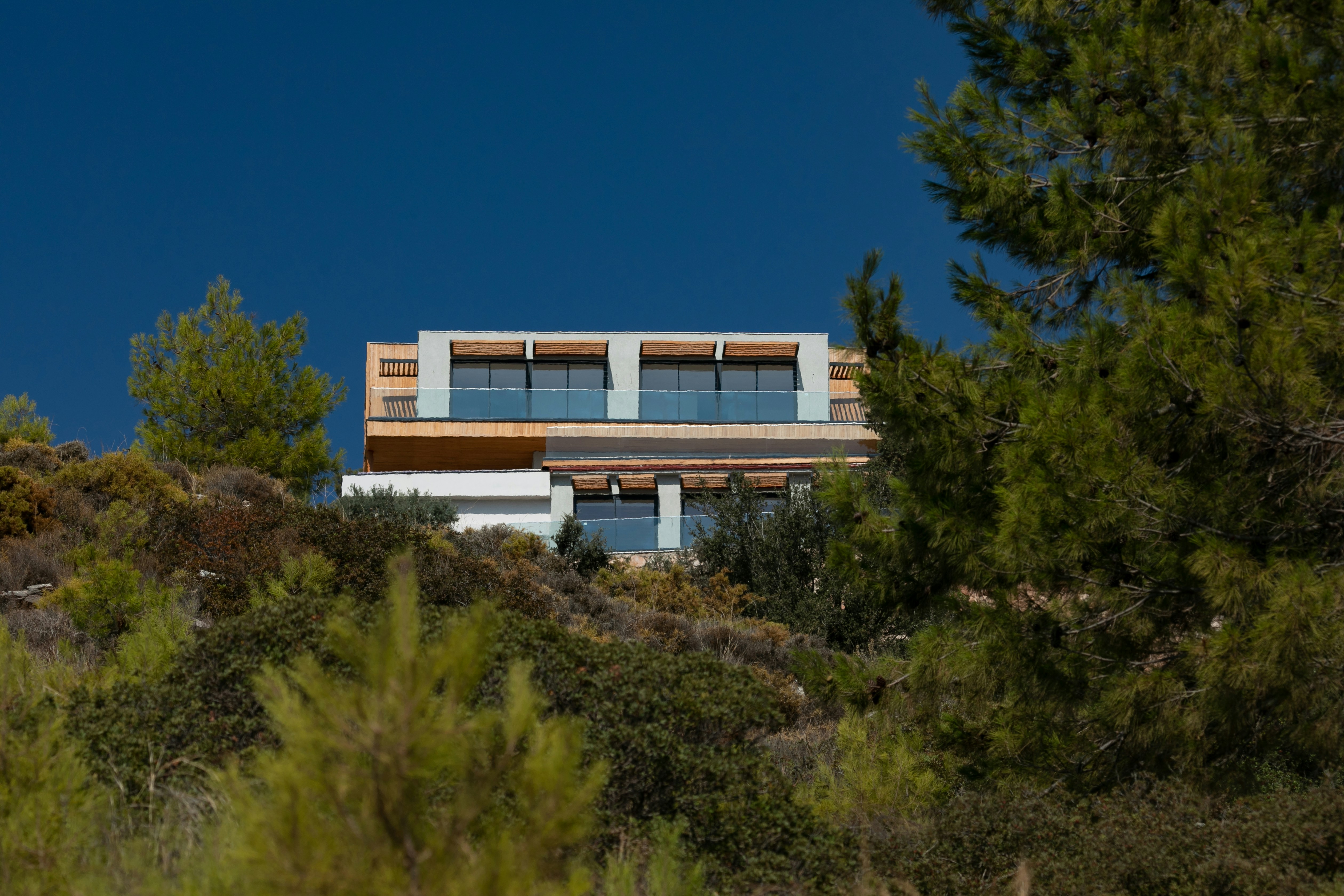 a house on top of a hill surrounded by trees